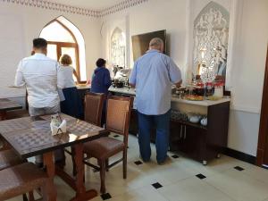 a group of people standing at a bar in a restaurant at An-Nur boutique in Bukhara