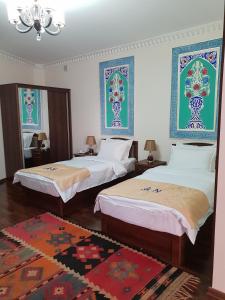 a bedroom with two beds and a mirror at An-Nur boutique in Bukhara
