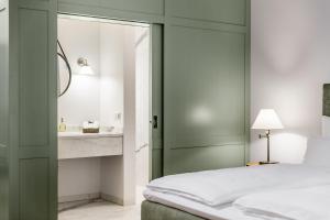 sypialnia z łóżkiem z lustrem i umywalką w obiekcie Hotel zum Glockenturm w mieście Marktl