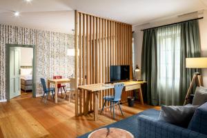 salon ze stołem i niebieską kanapą w obiekcie Hotel zum Glockenturm w mieście Marktl