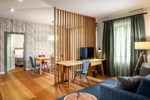 uma sala de estar com uma mesa e um sofá azul em Hotel zum Glockenturm em Marktl