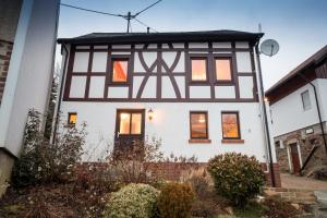una grande casa bianca con una casa bianca e nera di Haus Innerdorf gemütliches Ferienhaus im Taunus a Pohl