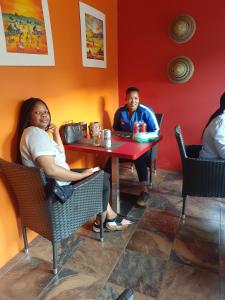 a group of people sitting at a table in a restaurant at Aloes Lodge in Leribe