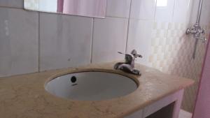 a bathroom sink with a faucet on a counter at Pauline Hotel Lira in Lira