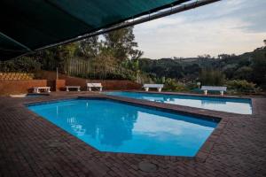 - une grande piscine bleue avec 2 tables de pique-nique dans l'établissement 17 Umdloti Resort, à Umdloti