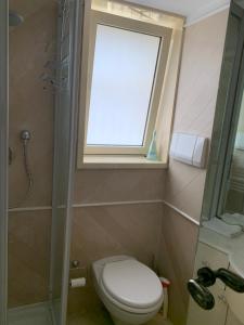 a small bathroom with a toilet and a window at Very Central suite apartment with 1bedroom next to the underground train station Monaco and 6min from casino place in Monte Carlo
