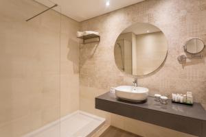 a bathroom with a toilet, sink, mirror and bath tub at AP Oriental Beach - Adults Friendly in Portimão