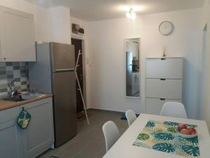 a kitchen with a table and a refrigerator at Cosy Home at 100 m from Iulius Town in Timişoara