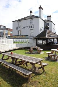 um grupo de mesas de piquenique em frente a um edifício em The Prince of Wales em Reigate