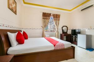 a bedroom with a bed with red pillows and a kitchen at Ngoc Linh Hotel in Ho Chi Minh City