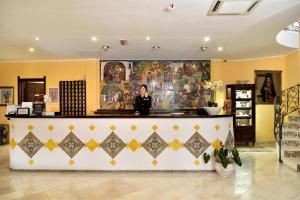 a woman standing behind a counter in a store at ECO HOTEL ORLANDO Sardegna in Villagrande Strisaili