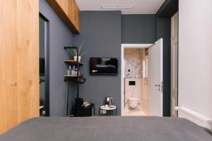 ブダペストにあるTG Hotel Apartments Budapestの青い壁のベッドルーム、トイレが備わります。