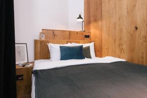 a bedroom with a large bed with a blue pillow at TG Hotel Suites Budapest in Budapest