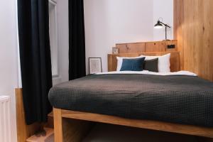 a bed room with a wooden head board at TG Hotel Suites Budapest in Budapest