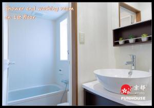łazienka z umywalką i prysznicem oraz salon na piętrze w obiekcie Funhouse Kaori w mieście Kami-tobachō