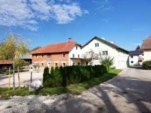 a white house with a fence and a street at Ferienwohnung Schmied 1 in Aurach am Hongar