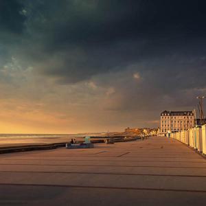 a beach with a cloudy sky and the ocean at Chambre d'hôtes Les Nymphéas in Wimereux