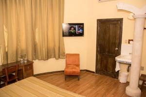 a bedroom with a bed and a television on the wall at Hotel Roma in Durango