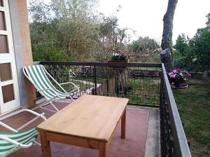 einen Holztisch und zwei Stühle auf dem Balkon in der Unterkunft Le Piagge in Nemi