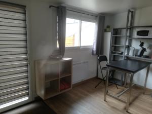 een kamer met een bureau, een tafel en een raam bij Aurillac meuble de tourisme in Aurillac