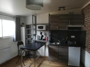 uma cozinha com uma mesa e um balcão preto em Aurillac meuble de tourisme em Aurillac