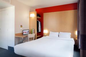 um quarto de hotel com uma cama grande e uma secretária em B&B HOTEL Orly Chevilly Marché International em Chevilly-Larue