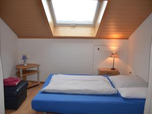 a bedroom with a blue bed and a window at Ferienwohnung Thelen in Wallbach