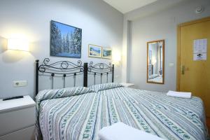 1 dormitorio con 1 cama con edredón azul y blanco en Pensión San Telmo / San Juan, en San Sebastián