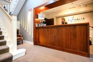 a woman sitting at a reception desk in a salon at Gleesons Townhouse Booterstown in Dublin