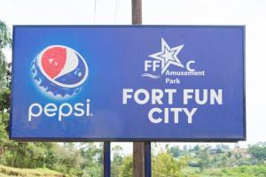 a blue sign for a for trump fun city at Fort Fun City Hotel Fort Portal in Fort Portal