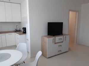eine weiße Küche mit einem TV auf einem Schrank in der Unterkunft Sobieskiego in Skierniewice