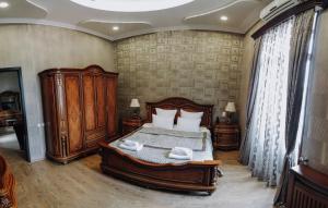 a bedroom with a large bed with wooden furniture at Old Telavi in Telavi