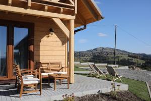 a wooden cabin with chairs and a table and chairs at Wilk i Owca in Istebna