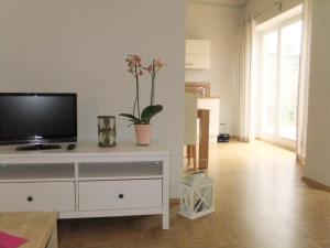 a living room with a tv on a white dresser at Gartenhaus Auguste in Dresden