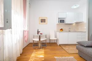 una pequeña cocina con mesa y sillas en una habitación en History Apartments Center, en Zadar