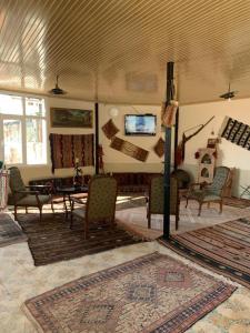 a living room with chairs and a table and a tv at OzenTurku Hotel in Pamukkale