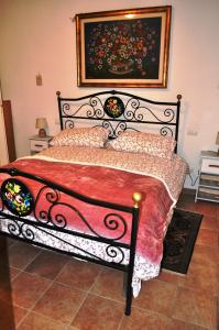 Schlafzimmer mit einem schwarzen Bett und einer roten Decke in der Unterkunft Il Ciliegio del Pellegrino in Gubbio