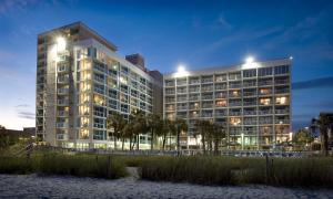 un gran edificio con sus luces encendidas por la noche en Captain's Quarters Resort, en Myrtle Beach