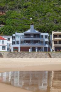 a building on the beach next to the water at Makarios On Sea in Herolds Bay