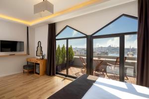 Schlafzimmer mit einem Bett und Blick auf einen Balkon in der Unterkunft DORUK PALAS HOTEL in Istanbul