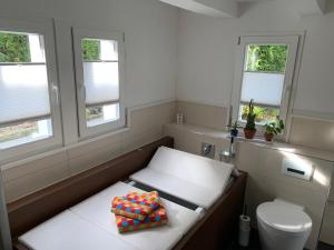 Kleines Zimmer mit einem WC und Fenstern in der Unterkunft Buxhaus in Solingen