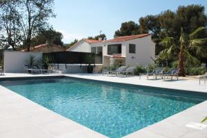 Home Cassis - Maison Les Calanques - Piscine chauffée في كاسيس: مسبح وكراسي ومنزل