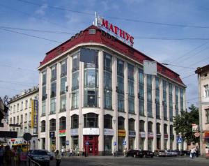 a large building with a sign on the top of it at Mini Apartment on Kulisha 29-3 in Lviv