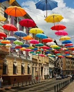 a bunch of colorful umbrellas hanging over a street at Mini Apartment on Kulisha 29-3 in Lviv