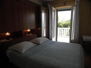 een slaapkamer met een groot bed en een groot raam bij Apartments Holiday in Lumbarda