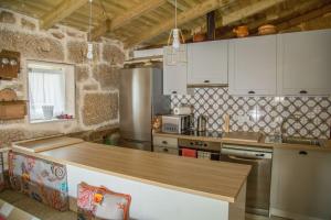 Castrelo de Miño的住宿－EL CIPRÉS DE PRADO，厨房配有白色橱柜和木制台面