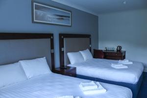 A bed or beds in a room at Heathrow Lodge 