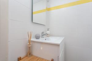 een witte badkamer met een wastafel en een spiegel bij MouraLua in Sintra