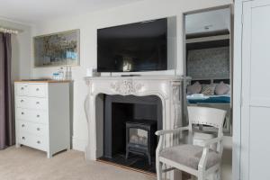 a living room with a fireplace with a tv above it at The Dog & Bear Hotel in Lenham