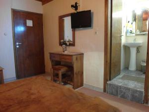 een kamer met een bureau, een spiegel en een badkamer bij Hotel Alexandrion in Kalamata